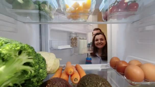 Щаслива Усміхнена Молода Жінка Чоловік Відкривають Холодильник Шукають Їжу Вид — стокове відео