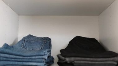 Düzenli katlanmış kıyafetlerin 4K 60fps videosu. Kamera dikey olarak hareket eder.