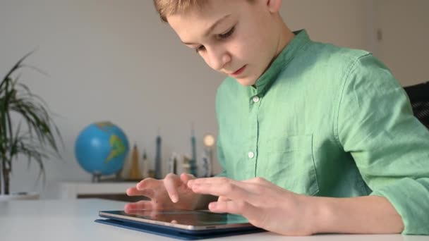 Συγκεντρωμένη Έφηβος Αγόρι Programming Χρησιμοποιώντας Tablet Κάθεται Στο Τραπέζι Στην — Αρχείο Βίντεο