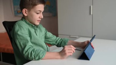 4K 60fps video uzaktan öğrenme tablet kullanarak evde oturan genç çocuk