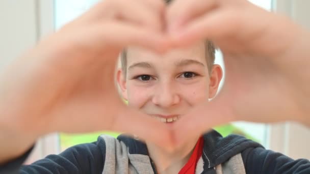 Χαμογελώντας Έφηβος Αγόρι Δείχνει Σχήμα Καρδιάς Δάχτυλά Του — Αρχείο Βίντεο