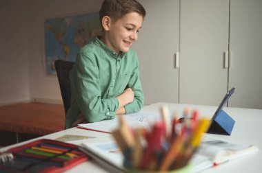 Mutlu liseli çocuklar online toplantılarda ya da evde tablet kullanarak video aramasında eğleniyor.