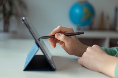 Tablet üzerinde kalemle vuruşan gençlerin fotoğrafını kapat 