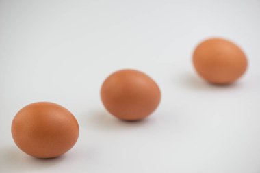 Beyaz zemin üzerinde birkaç taze kahverengi yumurta yakın plan