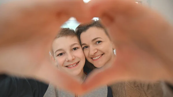 Šťastné Usmívající Mladá Maminka Její Syn Ukazující Tvar Srdce Rukama — Stock fotografie