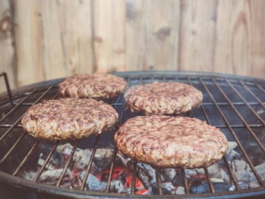 Yazın arka bahçede ızgara ızgaradaki büyük lezzetli hamburgerin fotoğraflarını çek.