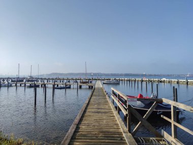 Baltık Denizi üzerinde boş ahşap limanlı günbatımı sahnesi