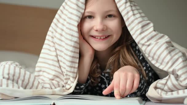 Πορτρέτο Του Χαριτωμένο Χαμογελαστό Κοριτσάκι Που Βρίσκεται Βιβλίο Στο Κρεβάτι — Αρχείο Βίντεο