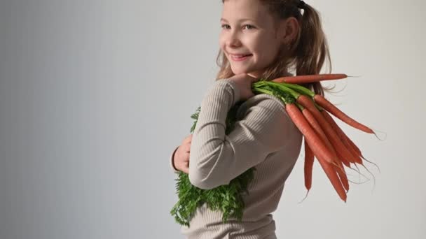 Видео Портрета Красивой Девочки Подростка Позирующей Свежей Морковкой Белом Фоне — стоковое видео