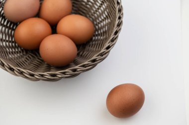 Beyaz arka planda Paskalya sepetinde taze kahverengi yumurta. Yukarıdan görüntüle