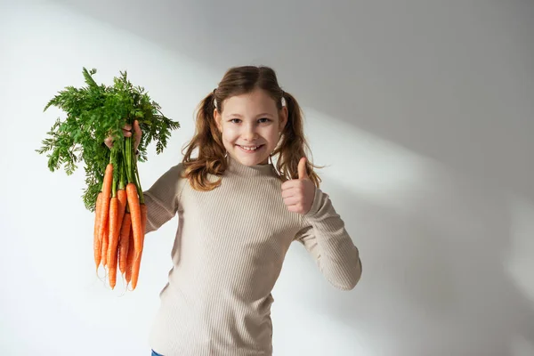 Sonriente Adolescente Sosteniendo Montón Zanahorias Naranjas Frescas Con Hojas Verdes — Foto de Stock