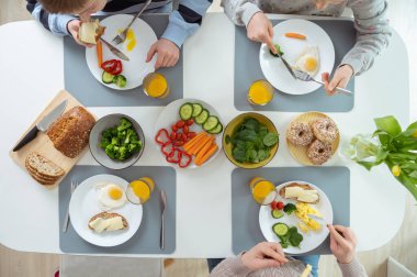 Aile sağlıklı bir kahvaltı yapıyor. Düz görünüm üstten