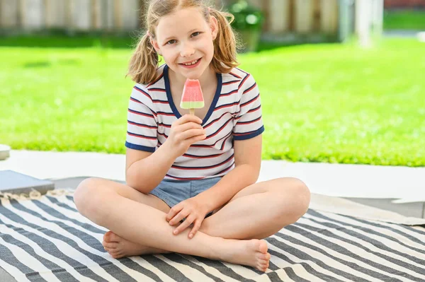 可爱的女孩在绿草背景上的公园里吃冰淇淋 — 图库照片