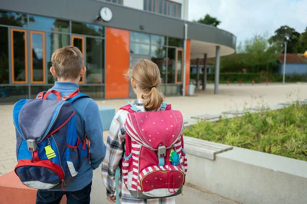 Två Tonårselever Med Ryggsäckar Framför Den Moderna Skolan Utsikt Bakifrån — Stockfoto