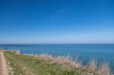 Kuzey Almanya 'da beyaz kum ve bulutlu gökyüzü ile mavi Baltık Denizi manzarası