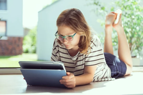 Cute Little Girl Glasses Lying Floor Balcony Learn Play Tablet — Zdjęcie stockowe