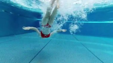 Little girl dive in swimming pool at resort at summer holidays