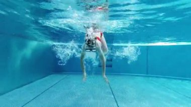4K video of cute little girl aving fun under water in swimming pool at summer holidays