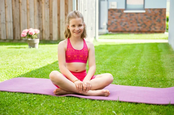 Cute Teen Blonde Girl Doing Exercises Yoga Mat Green Grass lizenzfreie Stockbilder
