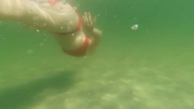 4K video of swimming teen happy girl underwater in tranquil sea at summer vacation