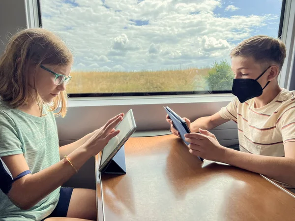 Έφηβοι Αδελφοί Και Αδελφή Που Ταξιδεύουν Σιδηρόδρομο Και Παίζουν Ταμπλέτες — Φωτογραφία Αρχείου