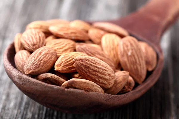 Noyau d'amandes dans une cuillère en bois — Photo