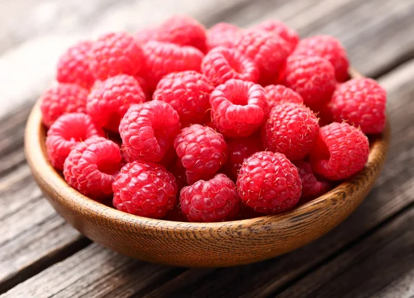 Fresh raspberry in a wooden plate — Stock Photo, Image