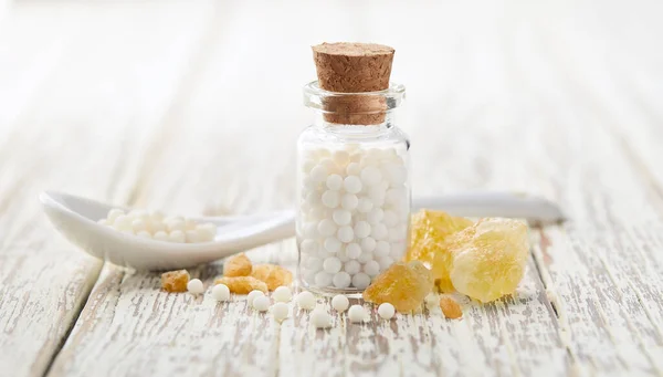 Rikkikide Homeopaattisilla Palloilla Valkoisella Puupohjalla — kuvapankkivalokuva