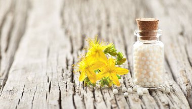 Homeopati ekolojik ilaç hiperikum granülleri ve John 'un otlu otları eski ahşap tahtada.