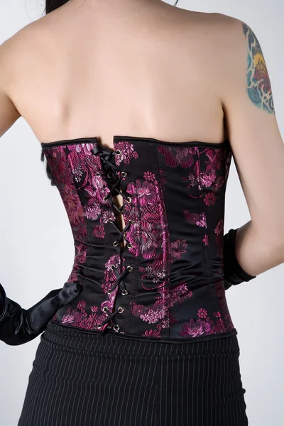 Rear view of a woman in black corset with floral embroidery Stock Image