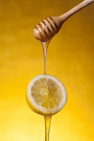 Close-up shot of honey flowing on lemon — Stock Photo, Image