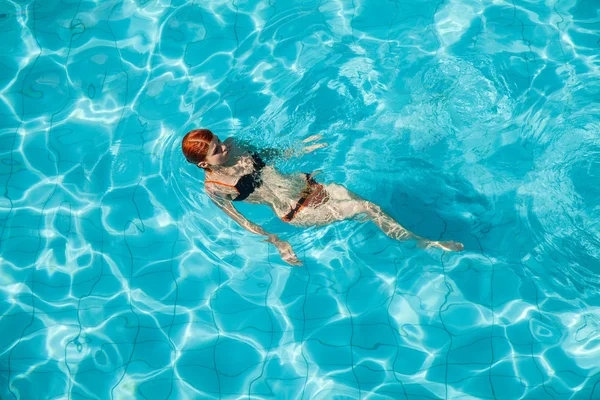 Mulher ruiva jovem na piscina — Fotografia de Stock