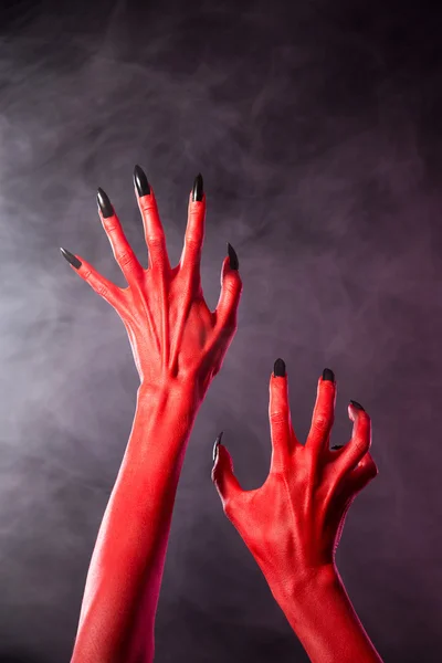 Mani rosse diavolo con chiodi neri, estrema body-art — Foto Stock