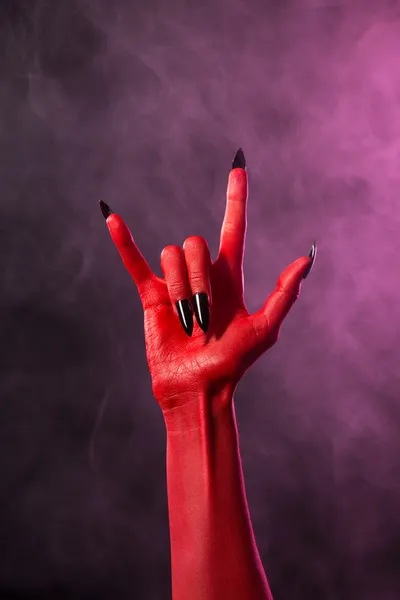 Каменный знак, рука красного дьявола с черными ногтями — стоковое фото