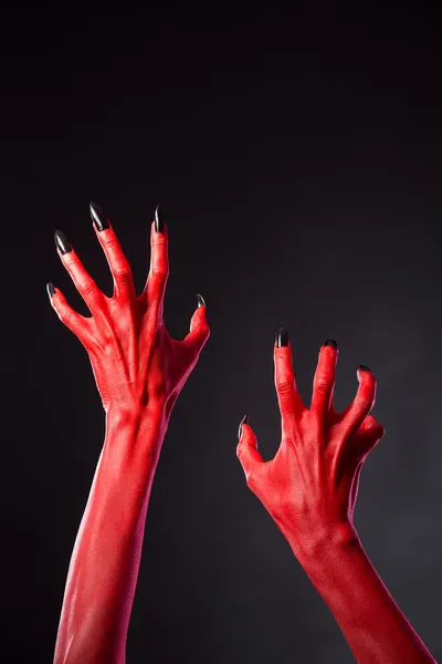 Mains du diable rouge avec des ongles noirs, véritable body-art — Photo
