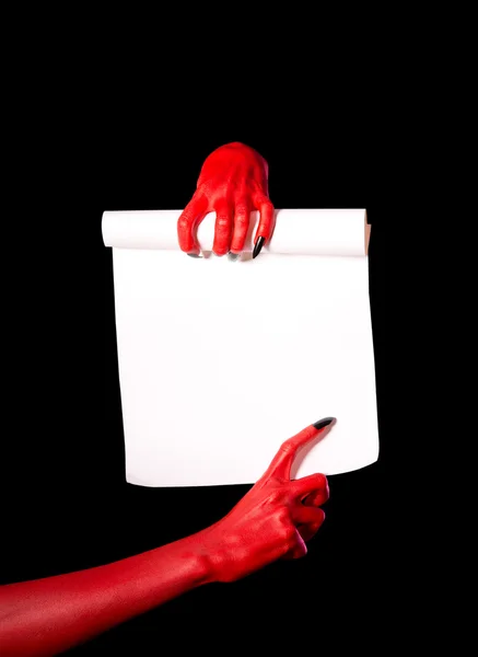 Red devil hands holding paper scroll — Stock Photo, Image