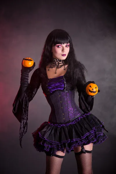 Улыбающаяся ведьма в фиолетовом готическом костюме на Хэллоуин — стоковое фото