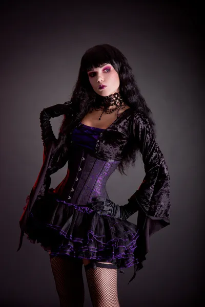 Романтическая готическая девушка в фиолетовом и черно-готическом костюме на Хэллоуин — стоковое фото