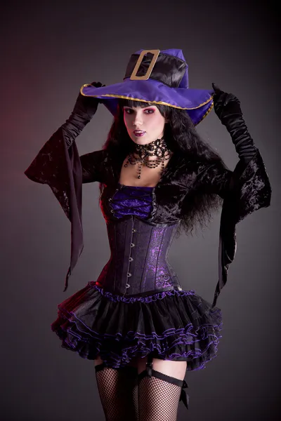 Sorcière souriante en costume d'Halloween gothique violet et noir — Photo