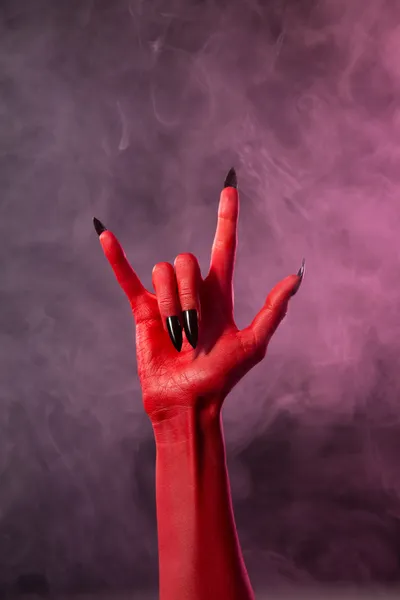 Metal pesado, mão diabo vermelho com unhas pretas — Fotografia de Stock