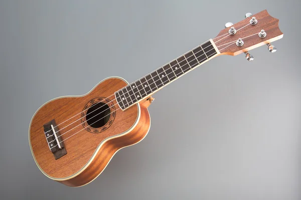 Chitarra ukulele su sfondo grigio — Foto Stock