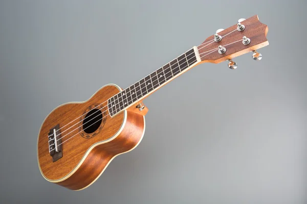 Hawaiian ukulele guitar on gray background — Stock Photo, Image