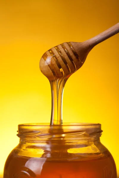 Close-up shot of wooden dipper with flowing honey — Stock Photo, Image