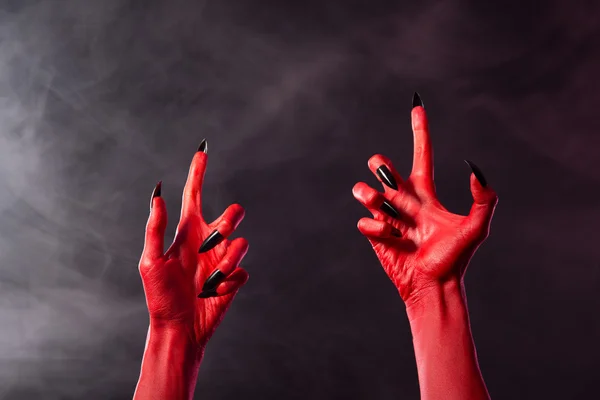 Straszne czerwony diabeł ręce czarny ostrymi gwoździami — Zdjęcie stockowe