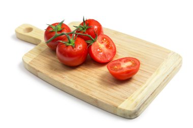 Fresh tomatoes on wooden chopping board