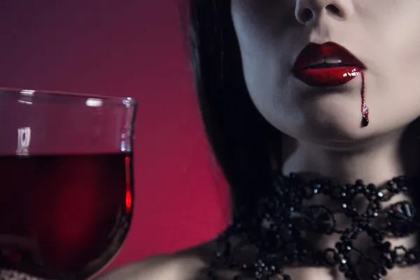 血液やワインのグラスを持つセクシーな吸血鬼の少女 — ストック写真