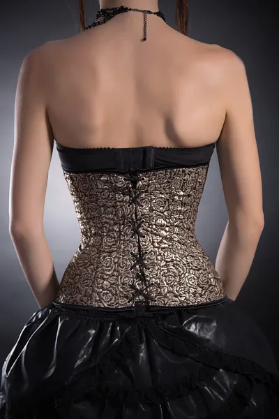 Rear view of woman wearing golden corset — Stock Photo, Image