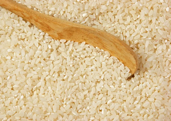 raw rice and wooden spoon