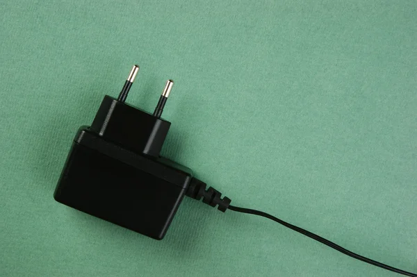 black charger adapter with plug on the green background