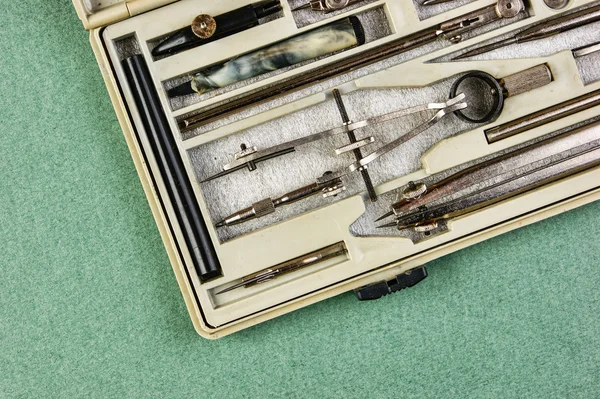 Old drawing tools in a box on a green background